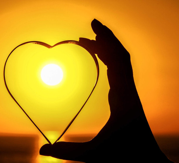 手持心脏的女人剪影，数码照片作为背景图片下载