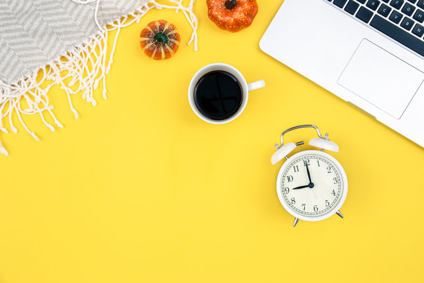 秋黄平放着笔记本电脑、南瓜和闹钟。图片下载