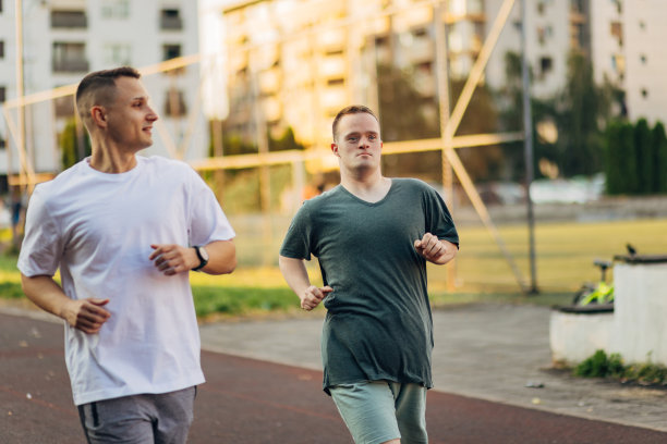 两个最好的男性朋友在一个阳光明媚的日子里在户外的运动场上慢跑图片下载