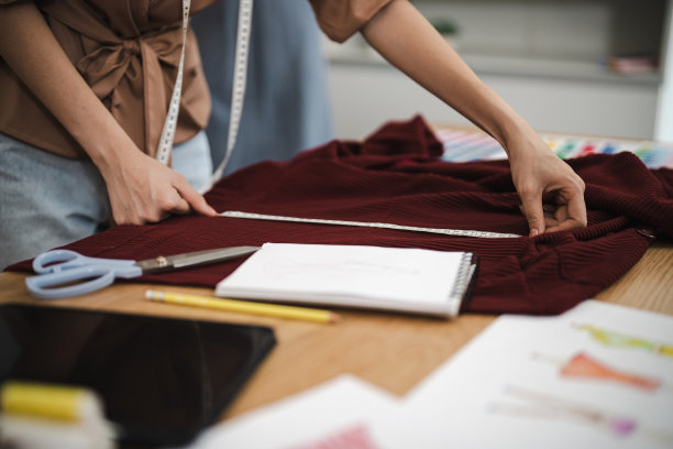 在裁缝店工作的女裁缝时尚的时装设计师在车间工作室设计新系列的服装制作和创意 时尚集合。图片下载