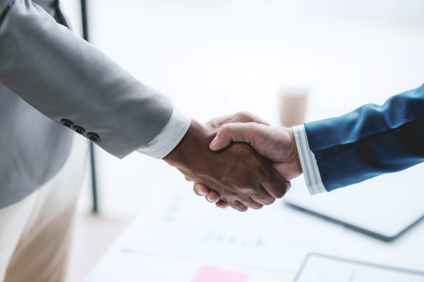 商业上的成功。商务人士握手协议确认在投资业务。成功的商业人士聚在一起。图片下载