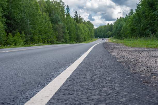 郊区的道路在森林中，通向远方。图片下载