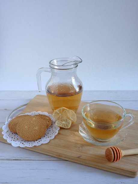 一杯新鲜的白茶，一些饼干和一片干柠檬。图片下载