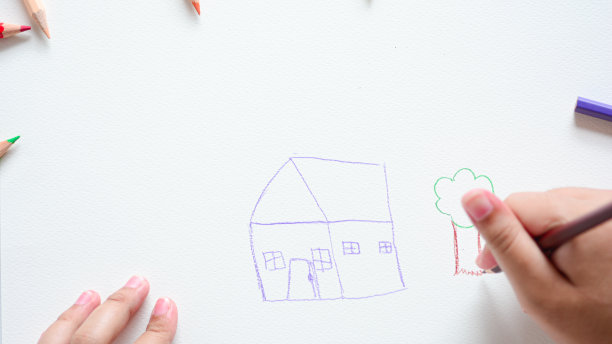 贴近孩子的手，用彩色铅笔在白纸上画画。图片下载