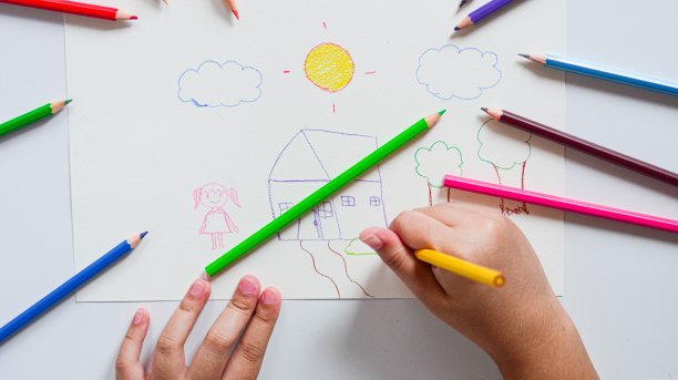 贴近孩子的手，用彩色铅笔在白纸上画画。图片下载
