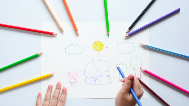 贴近孩子的手，用彩色铅笔在白纸上画画。图片下载