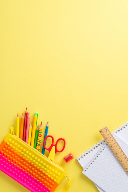 适合小孩子的迷人文具在俯视图垂直构图中排列:明亮的黄色背景上生动的彩色材料分类，为文本或广告提供了文案空间图片下载