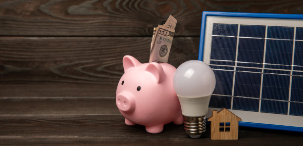 以太阳能板、led灯和存钱罐为背景的平面构图。节约资金和清洁能源的概念。生态与可持续发展的理念。图片下载