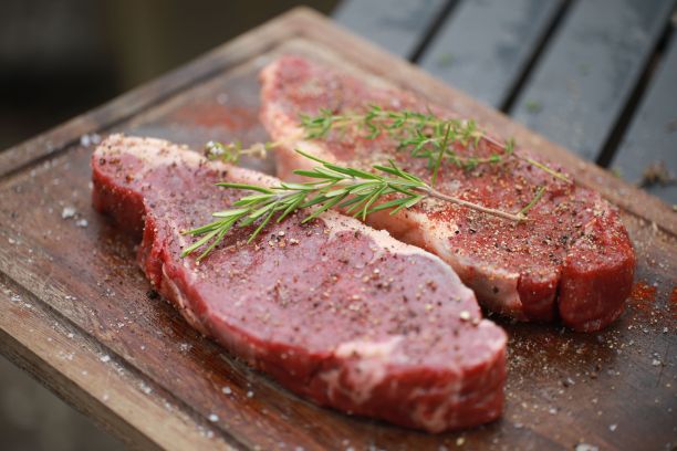 一盘多汁的腌牛排，用胡椒、盐和香草调味，准备煮图片下载