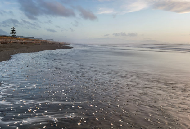 新西兰大泷海滩的长曝光照片，在暴风雨的日子里创造了平静的水域。图片下载