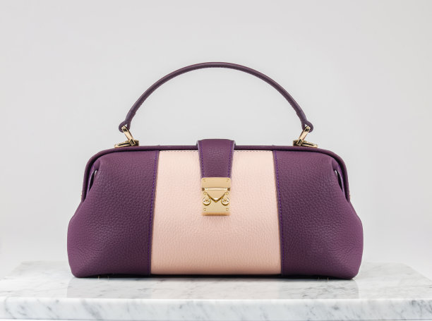 奢侈女包。紫色和粉红色的皮革手袋在白色的背景，大理石地板上图片下载
