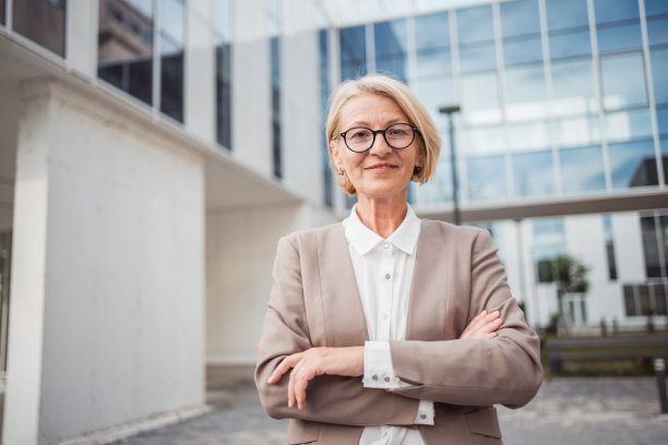 一位女商人双臂交叉站在办公楼前图片下载