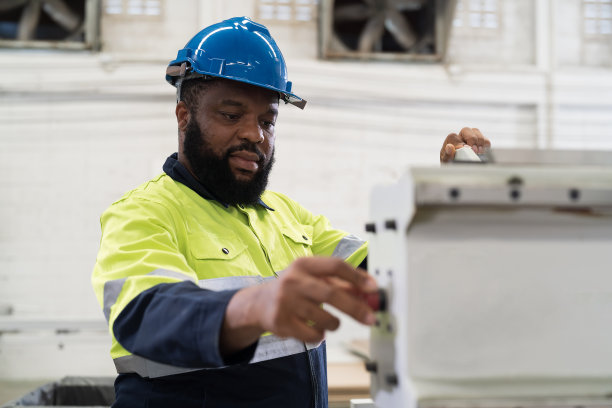 工厂男工人在工业工厂工作，操作数控机床。工厂工程师在工业工厂里维修机器的男工人图片下载
