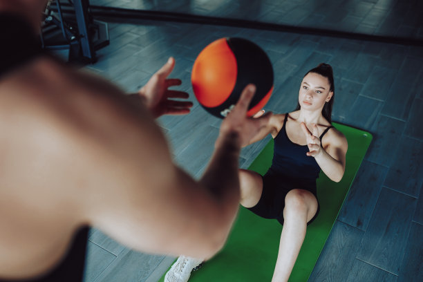男性私人教练授权年轻女性积极锻炼与球图片下载