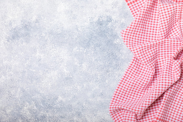 新的朴素图案的厨房毛巾折叠在一个有质感的桌子上。厨房用具。厨房毛巾或餐巾纸。文本的复制空间。放文字的地方。桌布。图片下载
