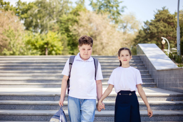 两个青少年的肖像，在去学校的路上，手牵着手。友谊的概念。回到学校图片下载