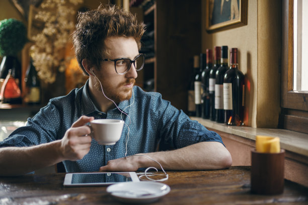 在吧台拿着平板电脑的书呆子图片下载