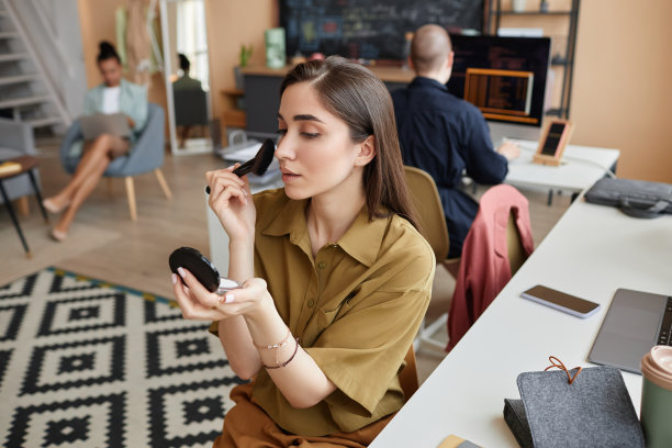 年轻的女商人在办公室工作场所化妆图片下载
