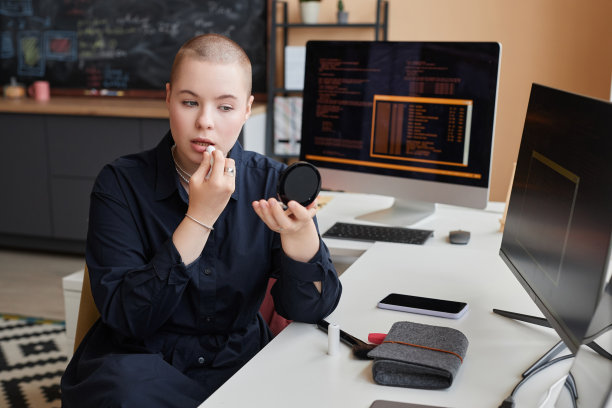 前卫的年轻女子在办公室化妆，对着镜子图片下载