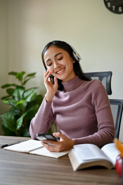 一幅快乐的亚洲妇女的肖像，她喜欢通过无线耳机听音乐图片下载
