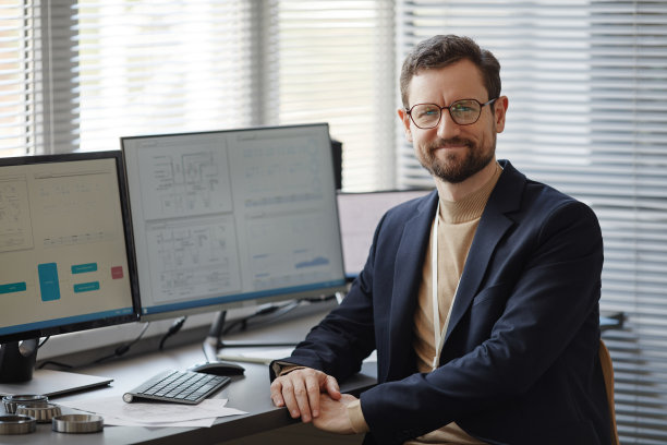 留胡子的男工程师在办公室看着镜头微笑图片下载