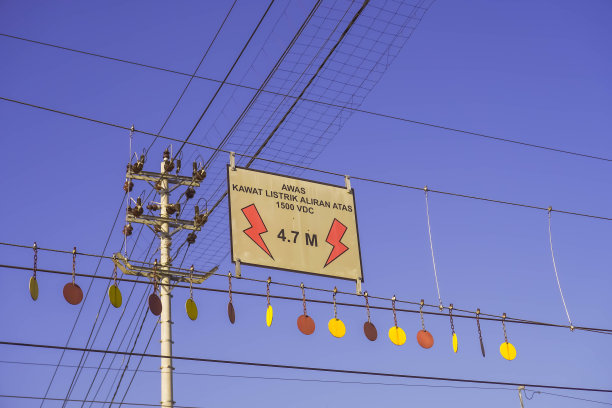 白天，电线、变压器和电线杆在蓝天背景下的照片。图片下载