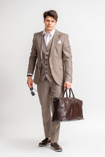 一个男人穿着商务三件套，带着一个大旅行袋出差。图片下载