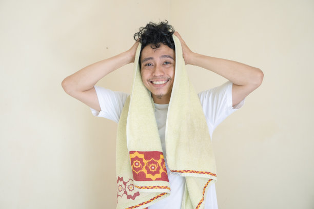 年轻人穿着白色的衣服，用毛巾做懒惰的手势。图片下载