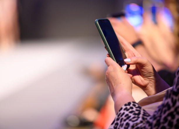 女子用智能手机拍摄时装秀图片下载