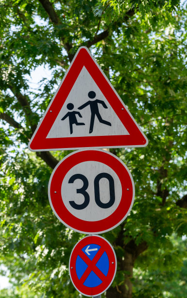 三个交通标志靠在树上图片下载