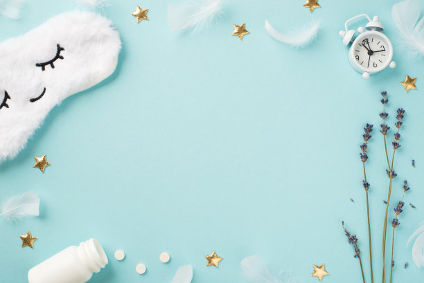 俯视图照片白色蓬松睡眠面具与闭上眼睛和微笑薰衣草闹钟打开瓶子药丸羽毛金色星星孤立的淡色蓝色背景与copyspace在中间图片下载