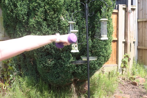 一张中年妇女在自家花园里做有氧和无氧混合运动的照片图片下载