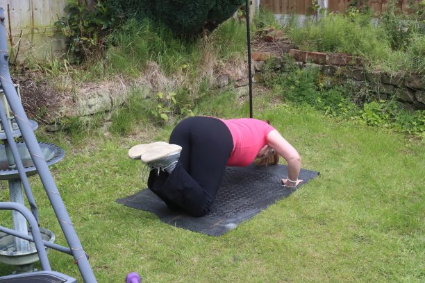 一张中年妇女在自家花园里做有氧和无氧混合运动的照片图片下载