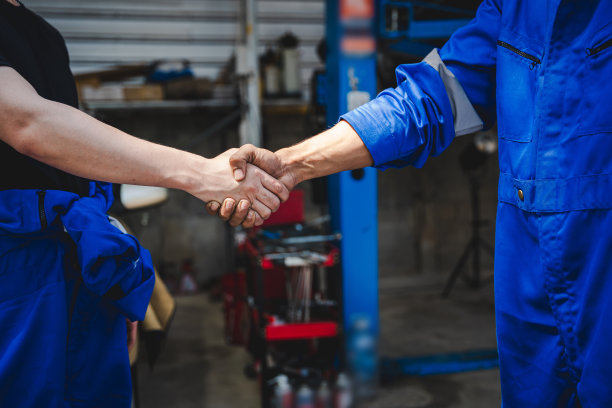 汽车机械师握手，显示机械师的成功合作，为客户检查和维护发动机。图片下载
