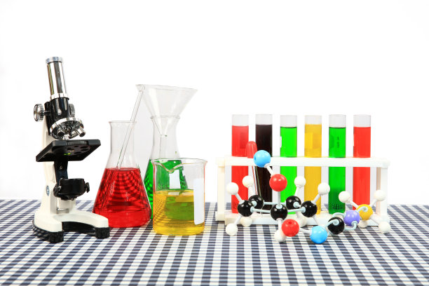 教育和科学实验室的玻璃器皿，白色背景的桌子上有彩色的溶液和显微镜图片下载