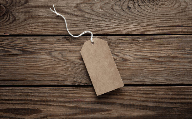 木桌上用绳子串着的空工艺品价签。设计模板图片下载