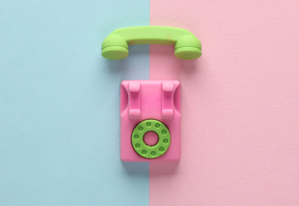 粉色蓝色背景上的微型旋转电话。俯视图图片下载