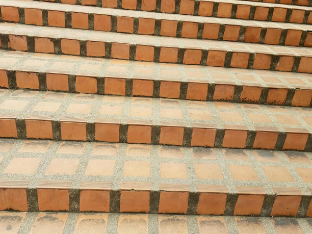 一张猫坐在楼梯上的照片，有一只猫坐在大楼的台阶上。图片下载