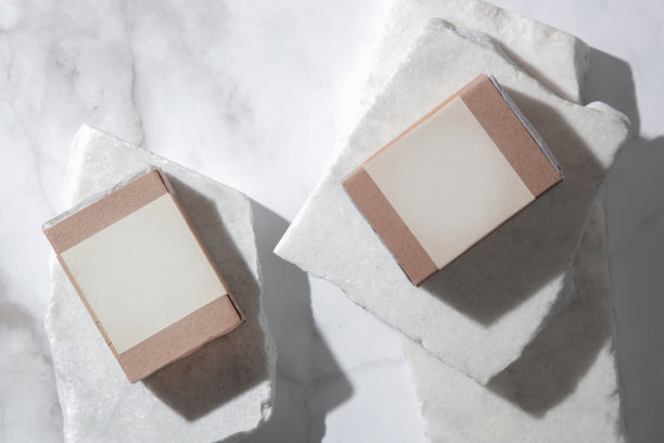 天然香皂，健康的皮肤和头发，在回收纸包装与空白标签，工作室拍摄大理石背景。化妆品的品牌和广告。图片下载