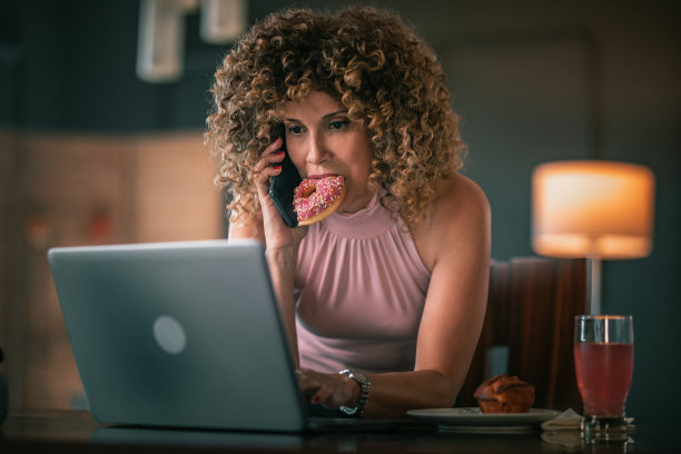 自由职业者一边吃早餐，一边在家用笔记本电脑工作图片下载