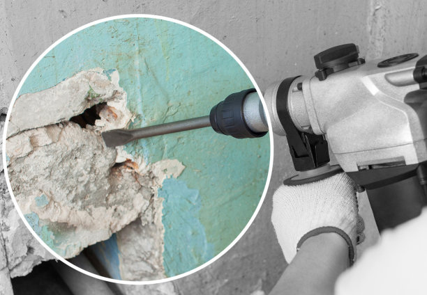 施工人员在施工现场用冲击钻打孔设备在墙上打孔。图片下载