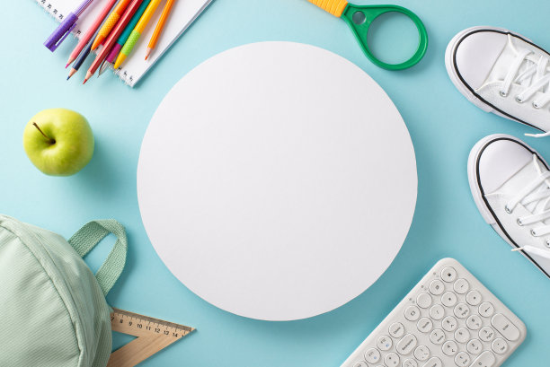 用现代技术理念学习。上面的帆布背包，一双运动鞋，键盘和文具与空圈复制空间孤立的淡蓝色背景的照片图片下载