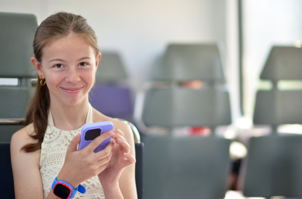 女孩在火车上用手机和智能手表看相机图片下载