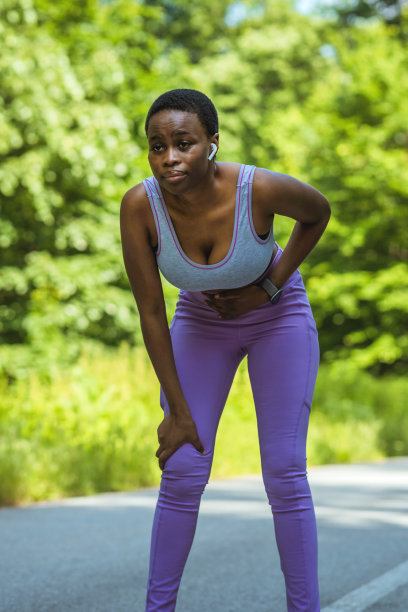 一名年轻的非洲女性在大自然中锻炼时胃痛的照片。图片下载