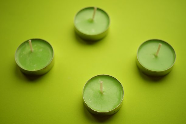 石灰桌上放着四支新的绿色蜡烛。俯视图图片下载