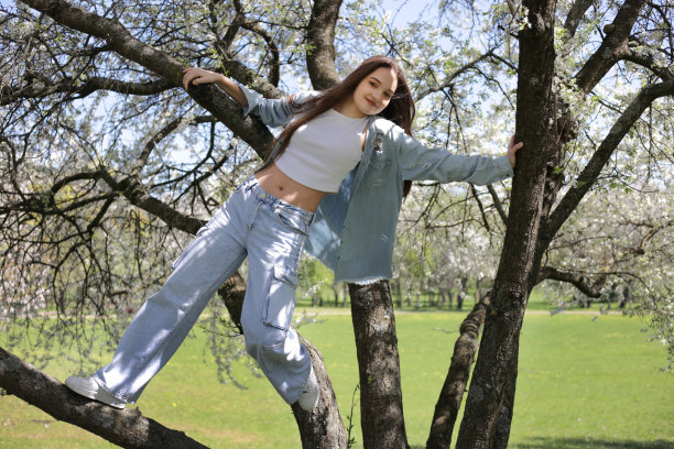 春天，女孩在树上摆姿势。图片下载