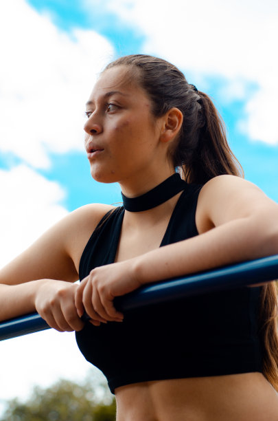 年轻女子在户外健身房锻炼的照片图片下载