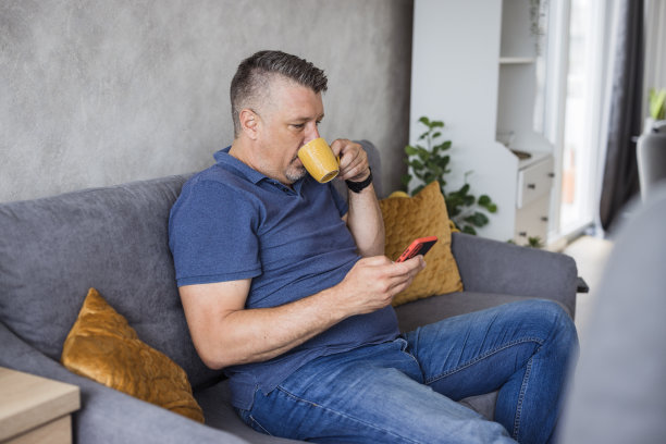 男子边玩手机边喝热饮图片下载