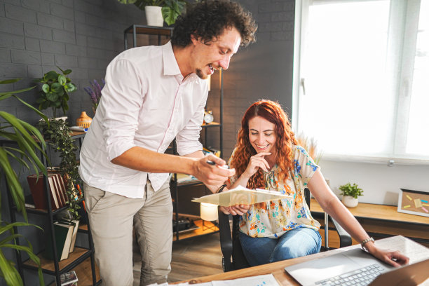 男员工向一位快乐的女雇主展示了一份积极的报告图片下载