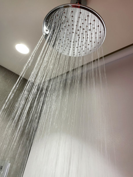 豪华浴室套房的银色不锈钢吊顶淋浴装置，从下面看，有强烈的喷水图片下载